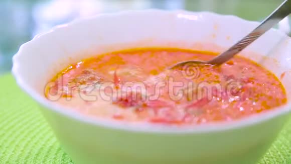 绿色桌子上放着带酸奶油的甜菜红蔬菜汤乌克兰食物视频的预览图