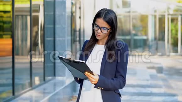 严肃的女商人站在办公楼附近她对工作人员的工作感到满意年轻漂亮的女性办公室视频的预览图