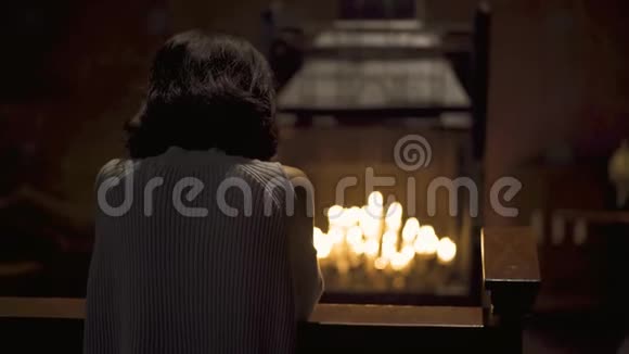 有蜡烛背景的女人在教堂祈祷视频的预览图