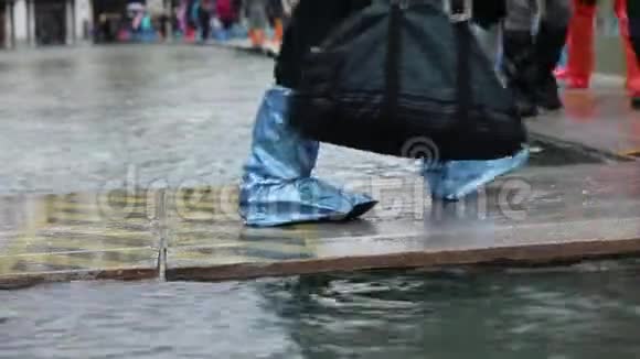 在威尼斯的涨潮期间穿着塑料鞋或靴子的人视频的预览图
