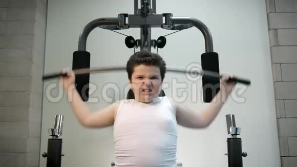 愤怒的男孩在健身房训练脂肪燃烧儿童观念超重坚韧视频的预览图