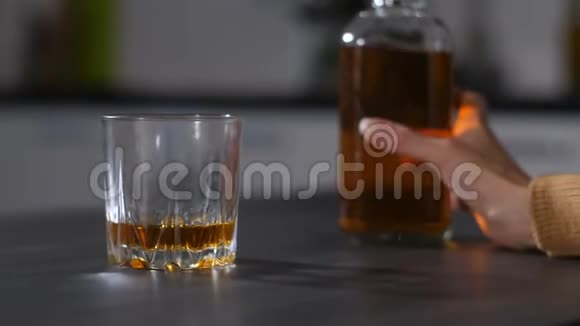女酒鬼手把酒倒进杯子里视频的预览图