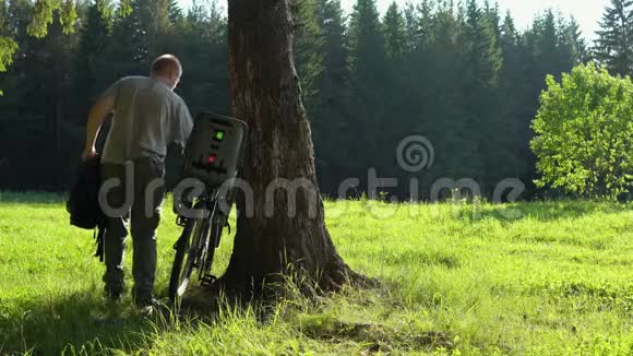 一个带背包的年轻男性旅行者带着一个带儿童座椅的自行车视频的预览图