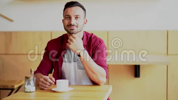 一个英俊的男人独自坐在咖啡馆里视频的预览图