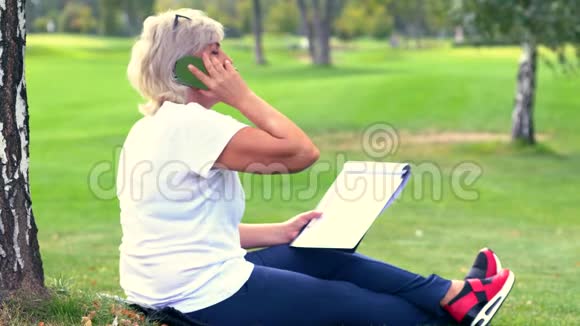 女人坐在她的手机上一边聊天一边画画视频的预览图