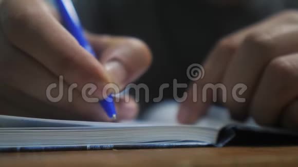 人在笔记本上写字男人的手生活方式写在记事本上概念商业教育男人做笔记视频的预览图