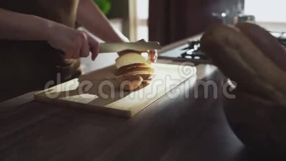 女人手拿刀在家厨房里切面包视频的预览图