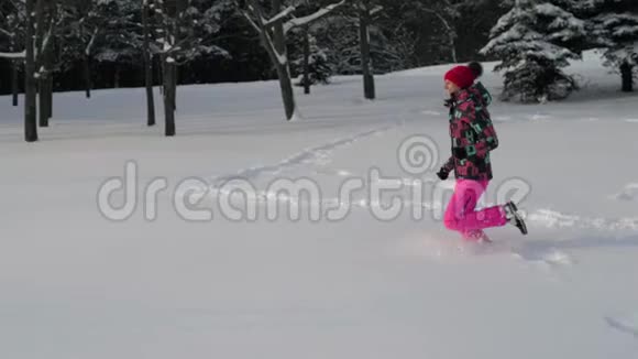 快乐的女人在冬天的雪地里奔跑视频的预览图