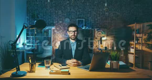 帅哥坐在办公室办公桌旁看着摄像机的延时肖像视频的预览图