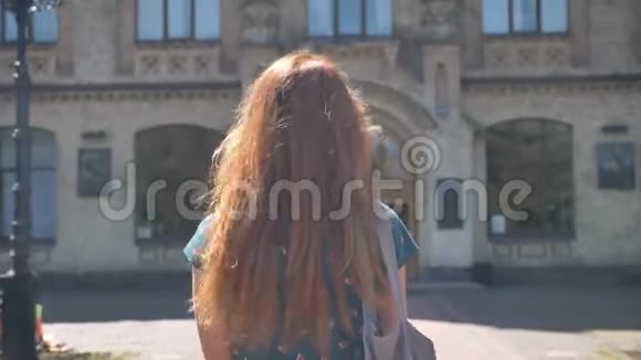 妩媚的姜姑娘走路转过身微笑着上大学或大学美丽的姑娘视频的预览图