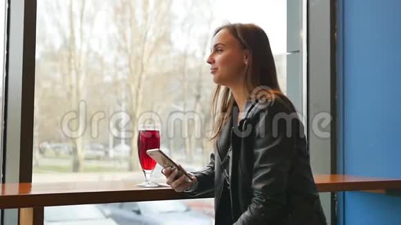 近距离观看年轻漂亮的女商人喝咖啡在家时用手机发送信息视频的预览图
