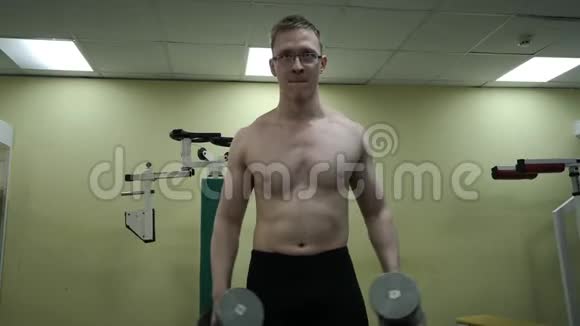 年轻人在健身房用哑铃训练肩膀视频的预览图