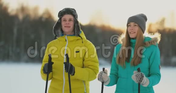 家庭滑雪者周末一起在树林里滑雪健康的生活方式慢动作可爱的一对视频的预览图