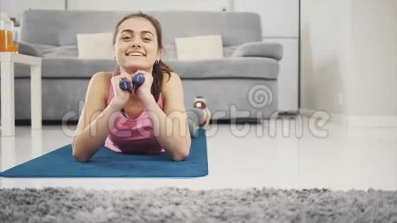 一个女孩喜欢在家健身同时微笑视频的预览图
