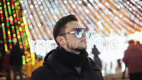 时尚的年轻人在庆祝新年城市圣诞树花环和灯光反射在镜子里视频的预览图