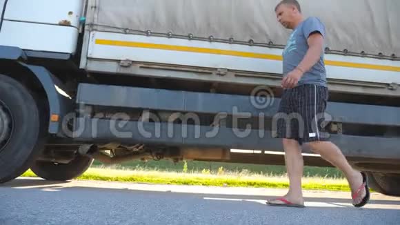 司机打开门坐在一辆停着的卡车上继续他的旅程人正走在卡车附近停放车辆视频的预览图