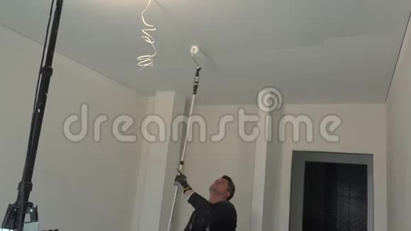 熟练工人用滚柱工具油漆白色天花板视频的预览图