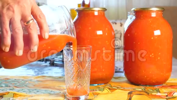 家庭主妇把刚酿好的番茄汁倒入玻璃杯中视频的预览图
