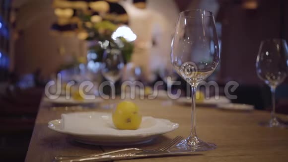 在一家昂贵的餐馆里提供一张桌子空酒杯白盘木桌上的餐具果汁柠檬视频的预览图