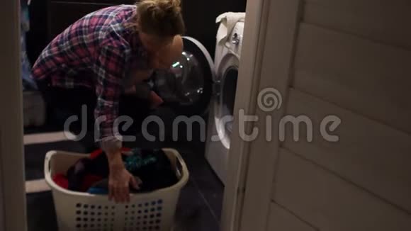 女人从洗衣机里拿出衣服她把孩子抱在怀里她很难应付视频的预览图