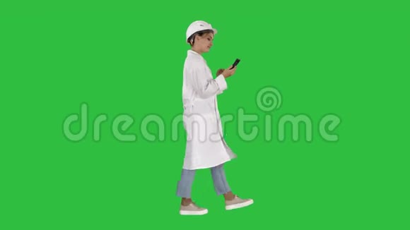 女科学家在绿色屏幕上使用智能手机行走Chroma键视频的预览图