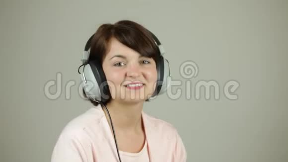 年轻漂亮的女士带着复古耳机微笑视频的预览图