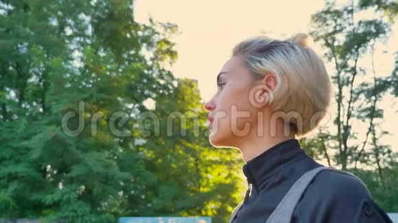 美丽的金发女人准备扔篮球站在公园里玩镜头耀斑视频的预览图