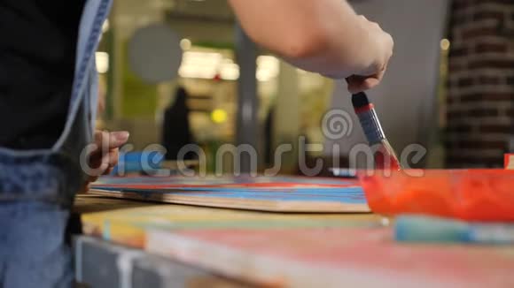 男孩和女孩用刷子在慢速运动中画板的特写镜头玩建筑设计师的小孩视频的预览图