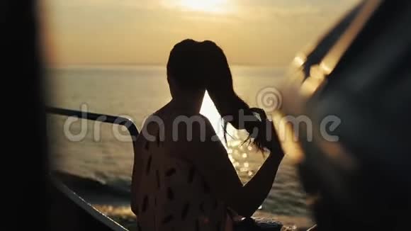 一位美丽的女孩站在一艘旅游船上欣赏日落视频的预览图