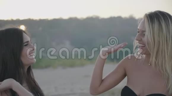 两位快乐的女性朋友在日落时分在海滩上度假视频的预览图