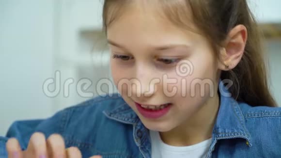 快乐小女孩在平板电脑上玩网络游戏的画像视频的预览图