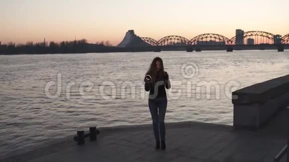 一位年轻的女士在日落时分用一个环形闪光灯作为补光灯自拍可以看到多加瓦河视频的预览图