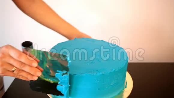 新做的巧克力蛋糕女人做蛋糕糖果师装饰蛋糕并用黄油霜覆盖它视频的预览图
