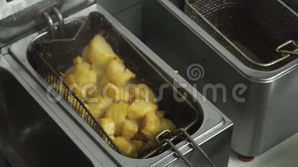 炸土豆就像炸薯条一样放入深油炸锅中的煮沸油放在咖啡馆的厨房再利用蔬菜视频的预览图