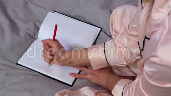 女人在笔记本上用红色写重音视频的预览图