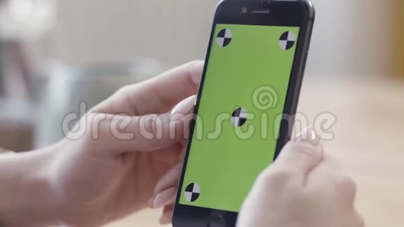 关闭女士手握智能手机与绿色屏幕显示在垂直位置库存录像女性视频的预览图