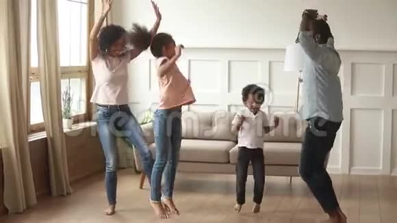 快乐的非裔美国人父母和可爱的孩子在家跳舞视频的预览图
