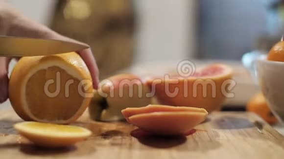 男手在砧板上用刀切黄柠檬节日桌为新年做准备视频的预览图