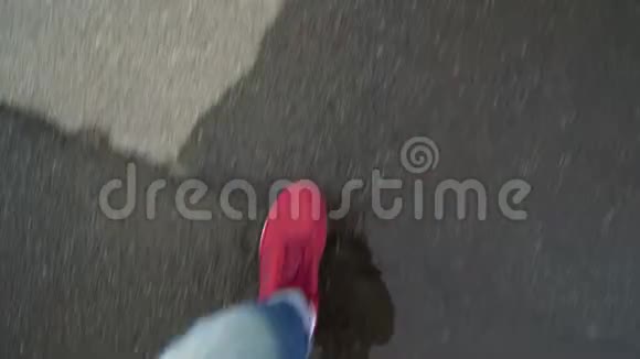 男子穿着红色运动鞋湿沥青上行走的俯视图视频的预览图