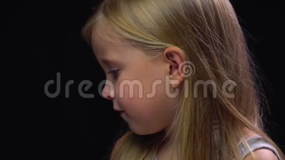 一个金发小女孩脸上带着微笑转身视频的预览图