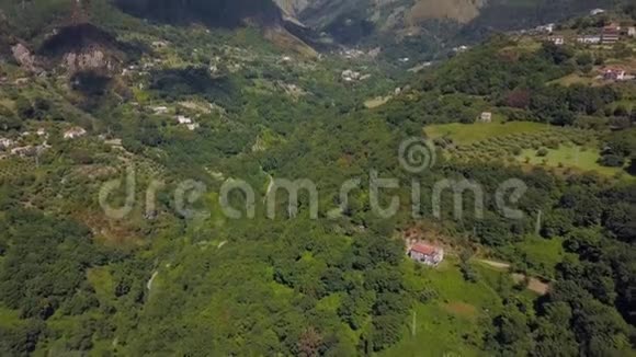 鸟瞰山峡谷丘陵被绿色森林覆盖无人驾驶飞机飞越山地丘陵地带视频的预览图