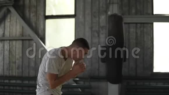 一个男拳击手的侧视在热身扭动他的身体臀部双手前脸训练过程拳击体育馆视频的预览图