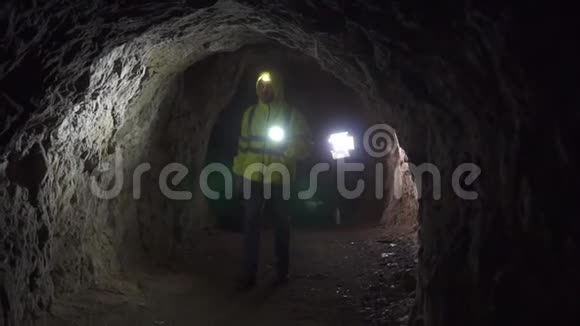 一位志愿者手里拿着手电筒额头上拿着手电筒在洞穴里寻找一个失踪的人慢悠悠视频的预览图