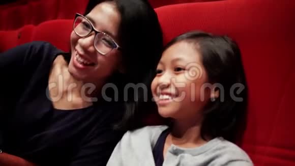 小女孩和妈妈在电影院看电影视频的预览图