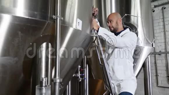 啤酒生产理念维修工人在啤酒厂剪贴板上写字酿酒厂的雇员视频的预览图