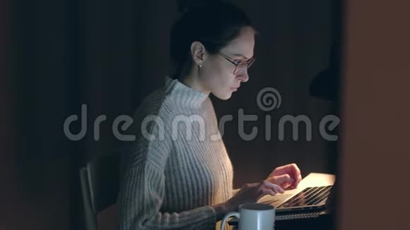 晚上坐在电脑前的黑发女人视频的预览图