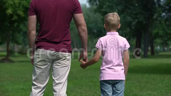 父亲和男孩牵着手走开了给儿子建议做真正的男人视频的预览图