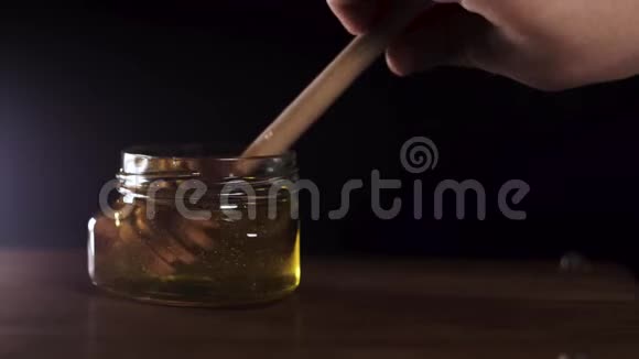 蜂蜜滴从罐子里的蜜汁里倒出来特写镜头厚厚的蜂蜜浸泡视频的预览图