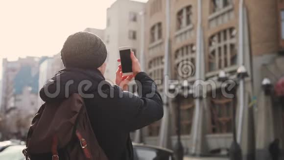 城市街头的男子游客拍摄建筑物视频的预览图