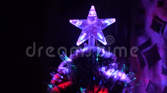 圣诞星在孩子们的房间里的圣诞树上闪烁着彩色灯光新年树上装饰着视频的预览图